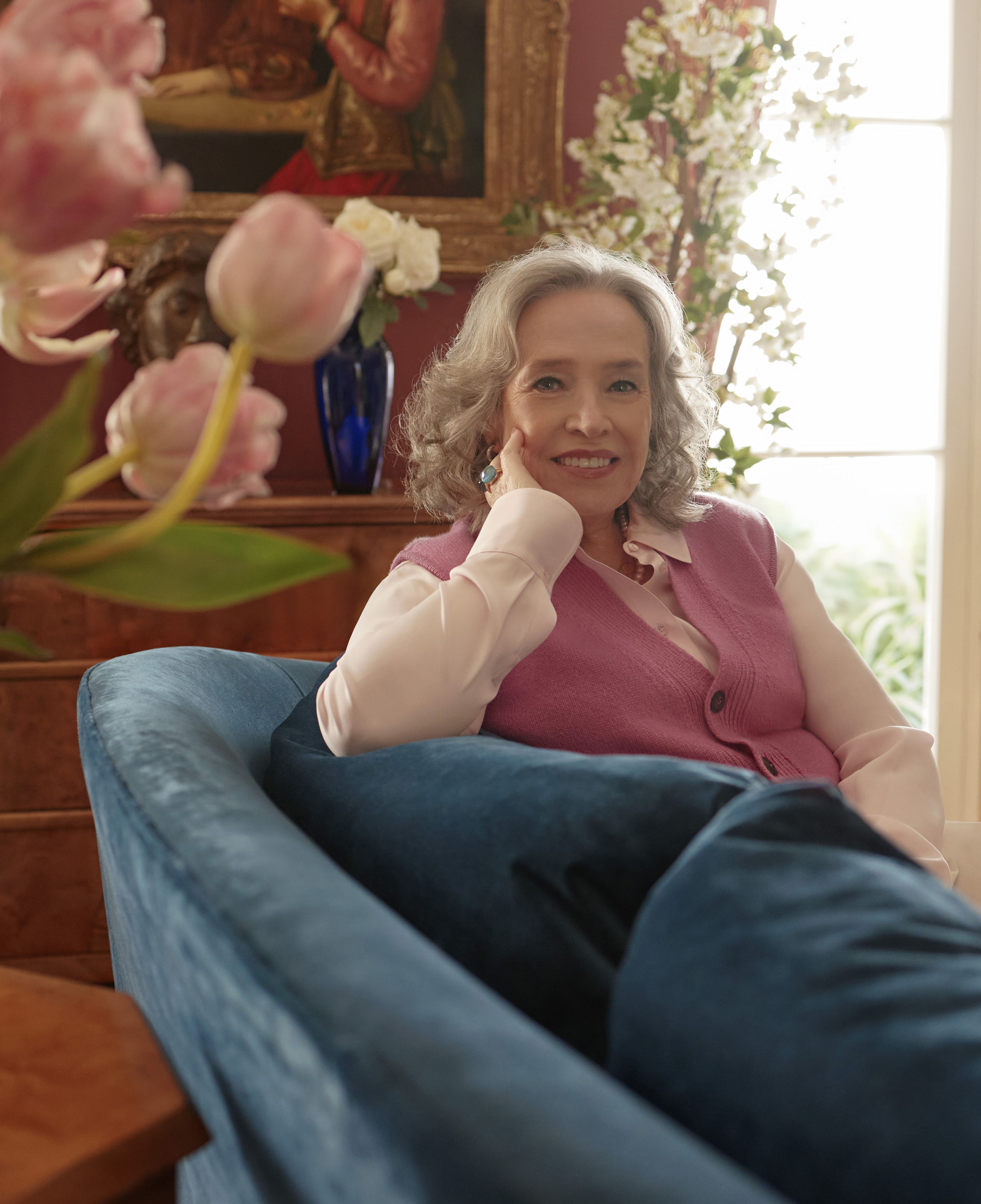 Photo of actor Kathy Bates sitting on a couch