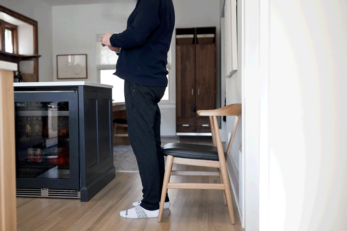 Video of a man demonstrating squats in his kitchen