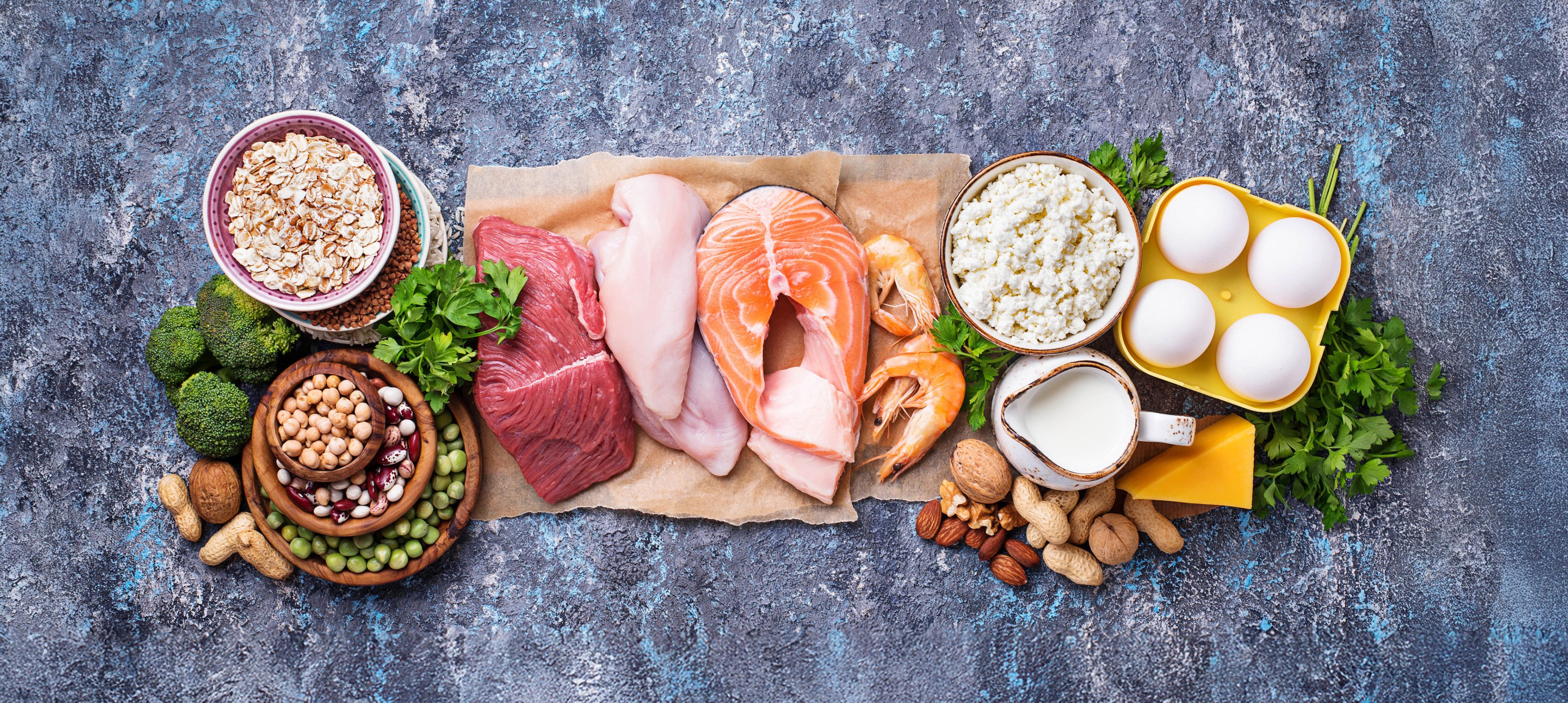 Photo of an assortment of foods that are high in protein including chicken, salmon, milk, nuts and eggs