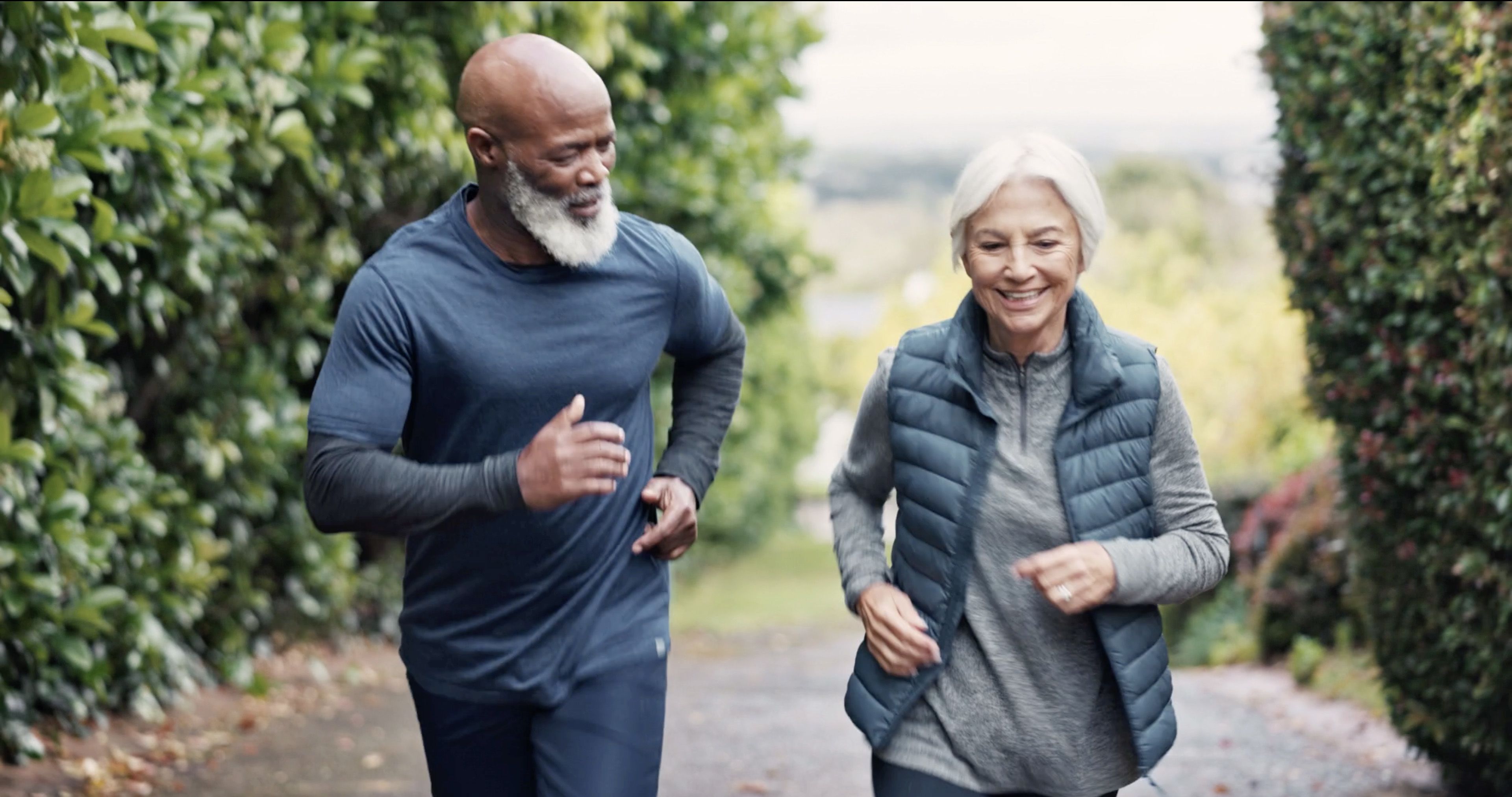 Photo of a man and woman jogging together outdoors